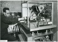 61019  Bill Dunlop working on wiring on the Rank prototype xerographic printer